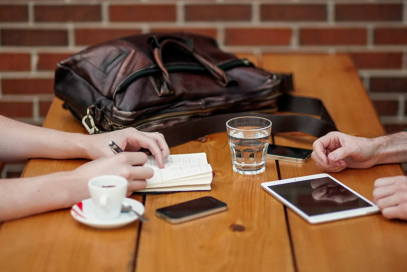 Two people discussing work with a tablet and smartphone