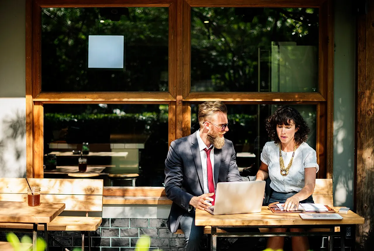 Two colleagues discussing work over a laptop